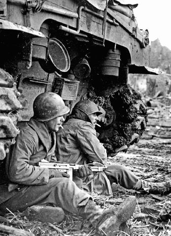 Dos soldados de la 9ª División de Infantería a cubierto en la parte trasera de un Sherman en el pueblo de Geich, en la zona industrial de Langerwehe. 11 diciembre 1944